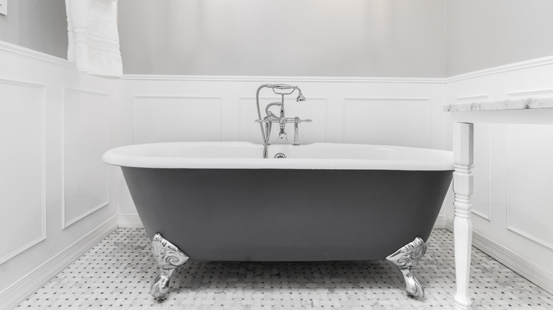 White wainscoting surrounding gray tub