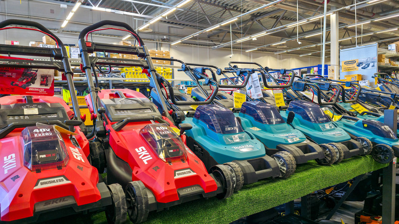 Electric lawn mowers on display in a hardware store.