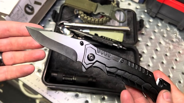 person holding knife from GORDON Emergency Survival Kit from Harbor Freight