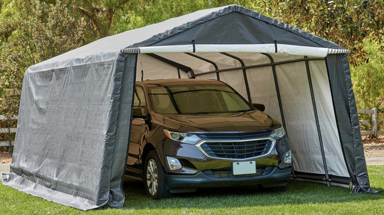COVERPRO portable garage surrounding mini van on a lawn