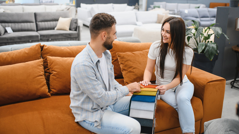 A young couple shopping for couch.