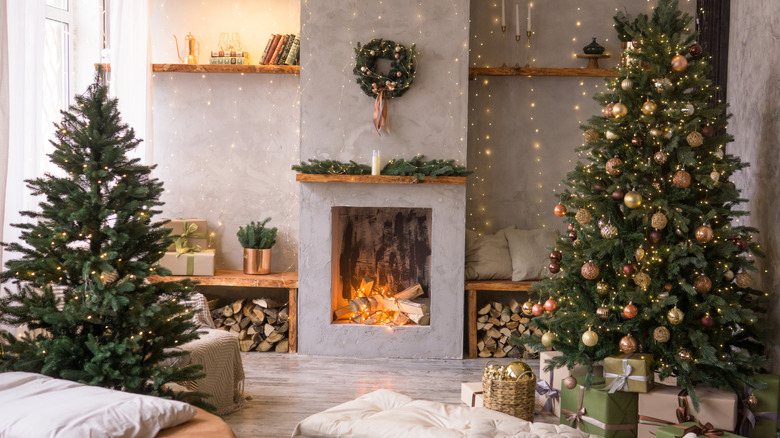 A cozy, minimalist living room with a fireplace is decorated for Christmas.