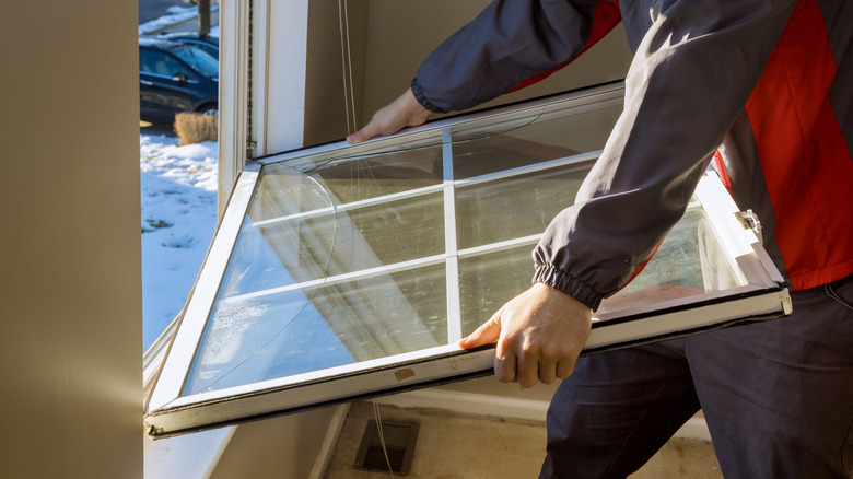 man removing old window