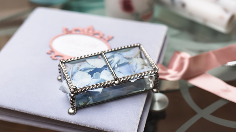 A glass box filled with flower petals