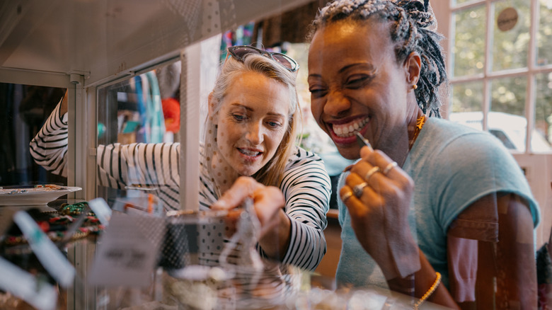 Two shoppers looking at some vintage items in a case at a thrift store