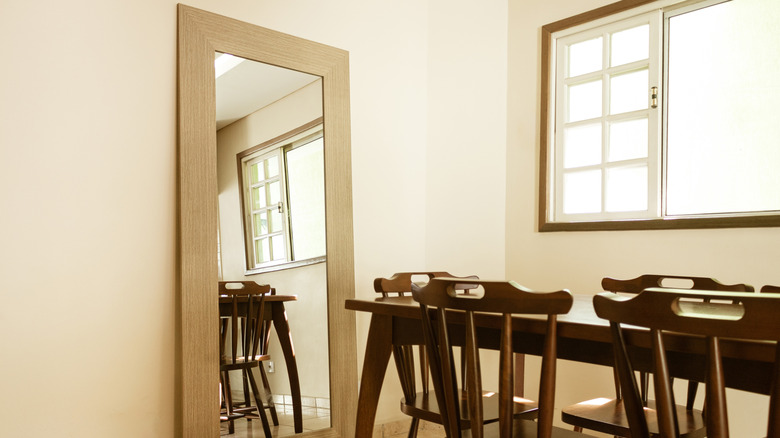 A long mirror next to a dining table and chairs
