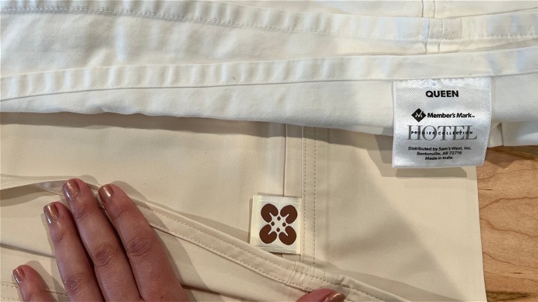 Bedsure beige sheet beside Member's Mark white sheet comparing stitch quality.