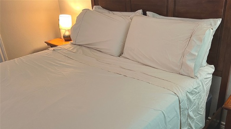 Closeup of wooden bed with beige Bedsure sheets.