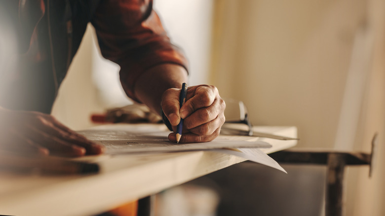 A person draws up plans for a kitchen design