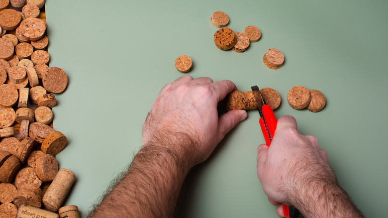 Man cutting a wine cork using a utility knife