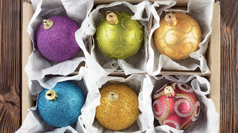 Glittery ball ornaments are stored in a box.