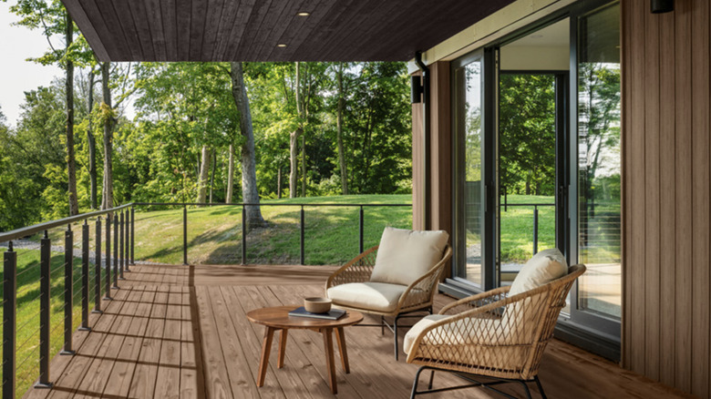 Covered, wooden deck stained in Taupe by Behr with two chairs