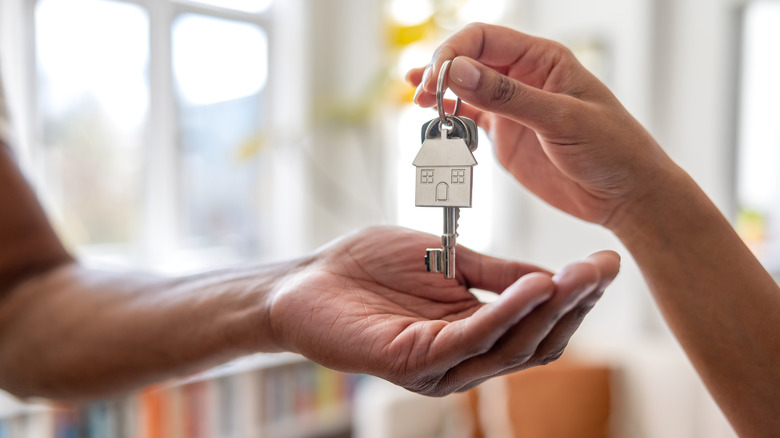 Close up of someone giving a house key to another person