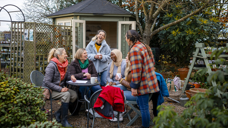 Gardeners laughing and drinking tea in a community garden