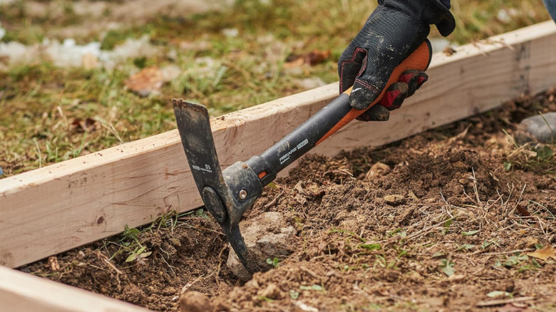 Close up of a person using  Fiskars' IsoCore Pickaxe Mattock