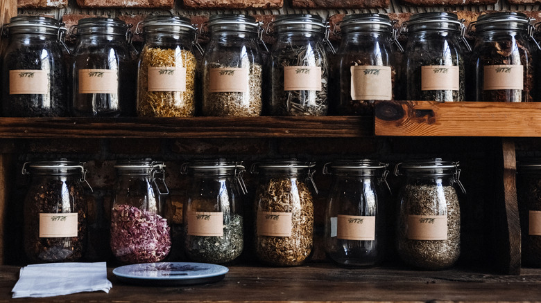 Glass Jars of Assorted Organic Freeze-Dried Foods on wooden shelf.