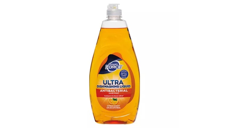 A clear squirt bottle full of orange dishwashing liquid