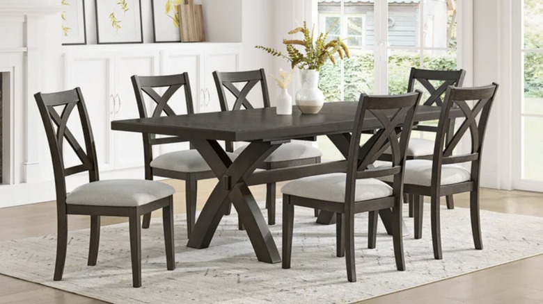 Dark wood table with six upholstered chairs in a light colored dining room