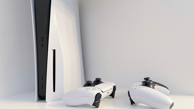 Playstation 5 next to two contollwers on a white table