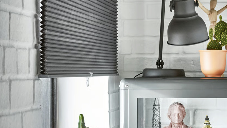 The HOPPVALS blinds from IKEA hanging in a room with whitewashed brick walls and decor