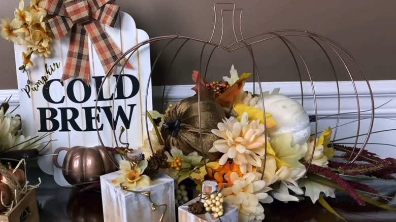 Wire pumpkin-shaped wreath form with flowers inside