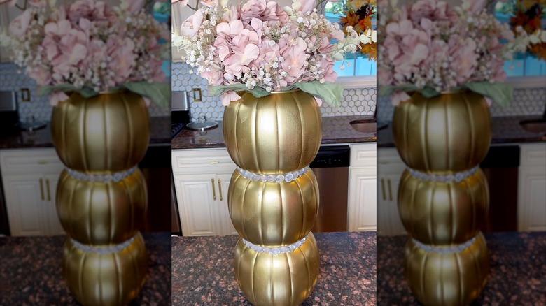 Gold pumpkins holding pink flowers