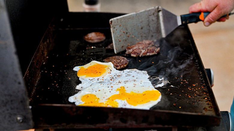 Person cooking breakfast food on a Blackstone grill