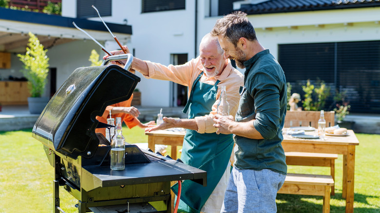 A father and son talking while grilling outside
