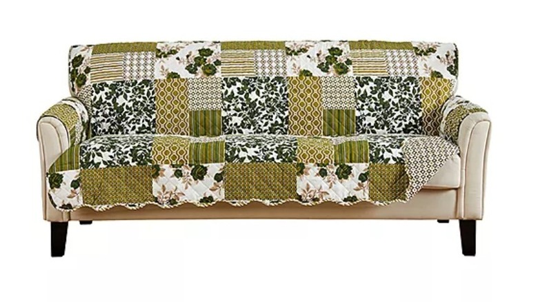 A close-up photo of a green patchwork sofa protector resting on a couch.