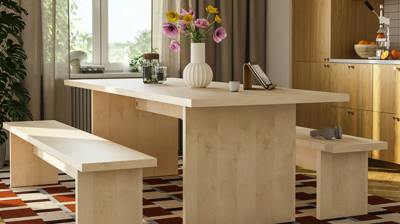 BERGSHYTTAN / BERGSHYTTAN Wooden table and two benches in a kitchen with a rug near a window