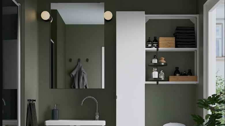 Image of white IKEA ENHET wall shelf mounted above a toilet in a gray and white modern bathroom