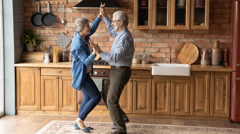 middle aged couple dancing in kitchen