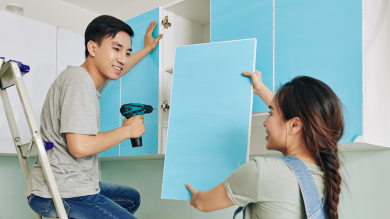 couple putting cabinets together