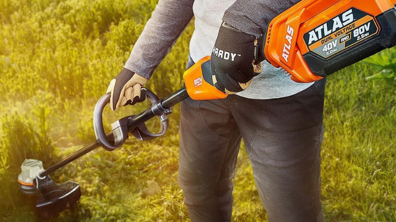A person using an Atlas string trimmer