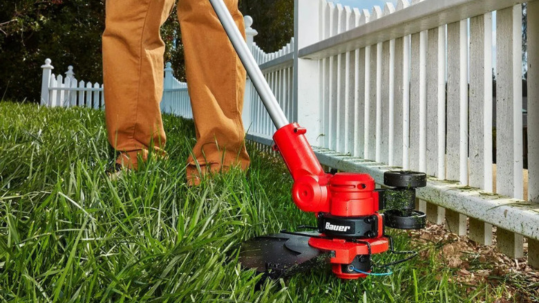 A close-up of somebody using a Bauer string trimmer