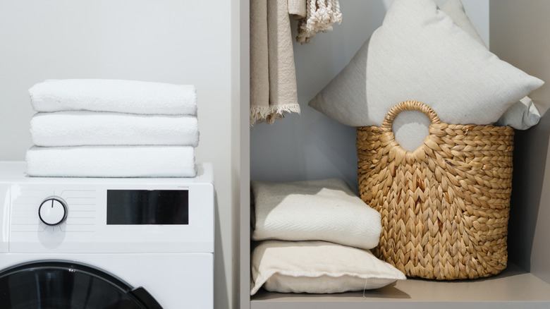 Laundry closet with washer and basket on shelf