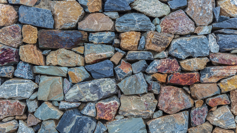 A retaining wall is made from multicolored quartzite stones