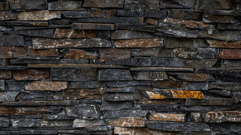 A close-up photo shows a retaining wall made from dark gray slate