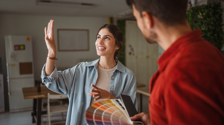 woman and man in living room choosing paint color
