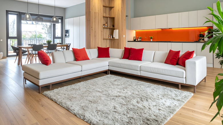 A modern living room with a large pillow-covered sectional.