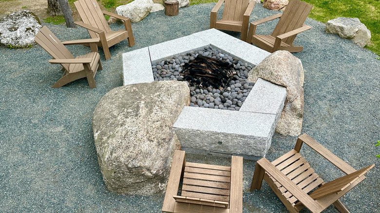 Rock fire pit built around large rocks in landscape