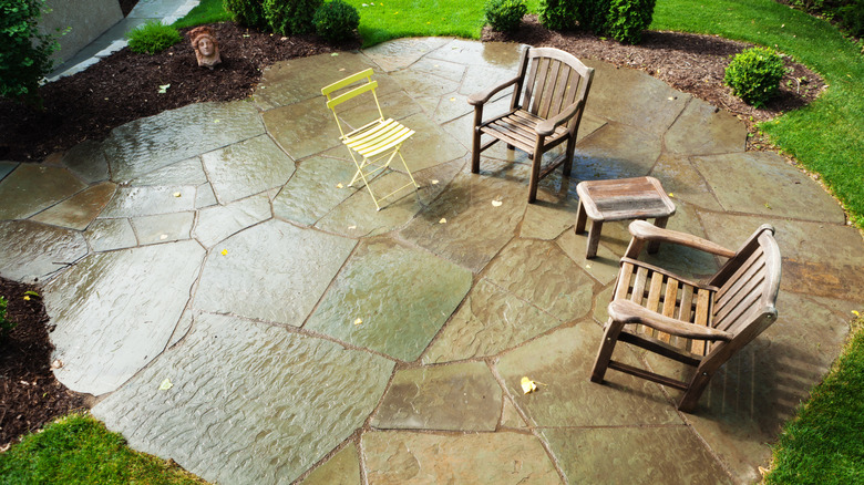 A timeless flagstone patio area with chairs on it
