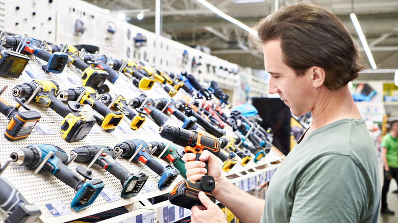 A man shopping for a drill in a hardware store