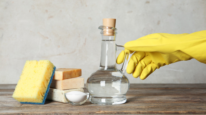 person reaching for cleaning supplies 