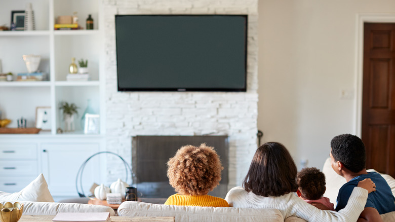 family watching mounted tv