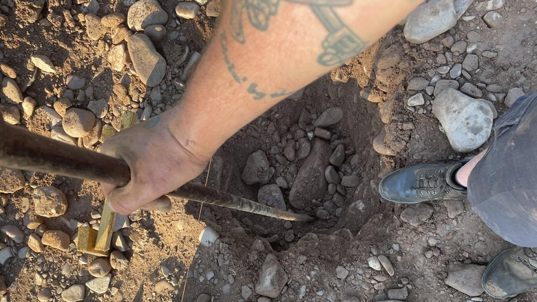 Man using a digging bar in rocky soil