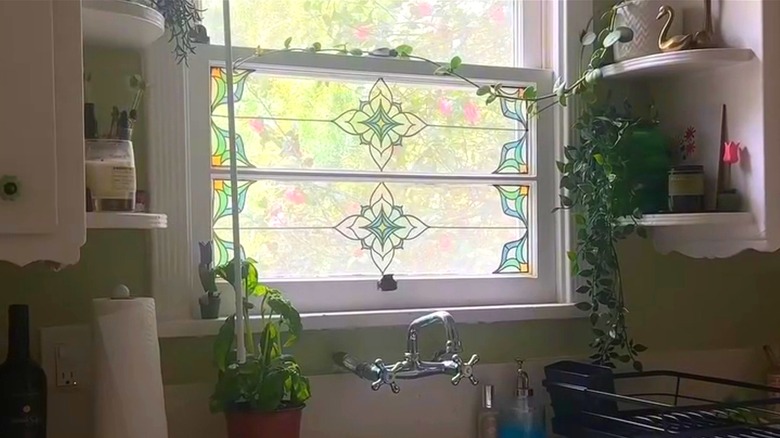Kitchen window with stain glass appliques on bottom panel.
