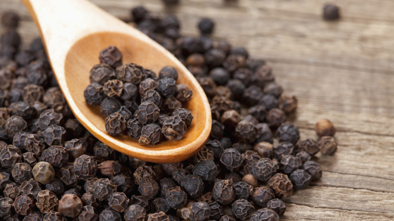 black peppercorns on spoon