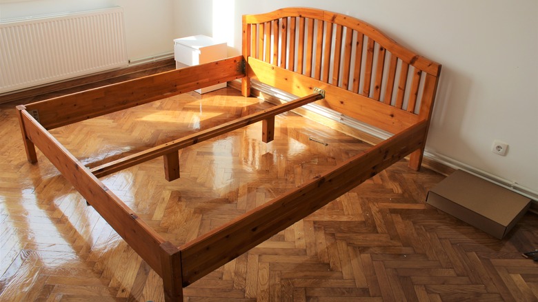 Wooden bed frame in empty room