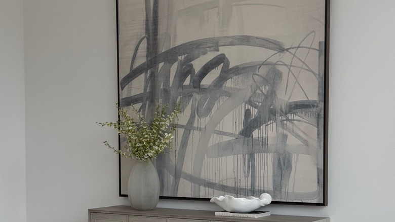 large abstract painting above entryway table